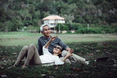 Portrait of a smiling young man sitting on grass