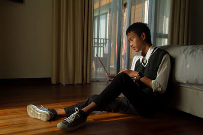 Portrait of young woman sitting on floor at home