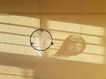 Ball hoop in school sports hall with shadows on wall