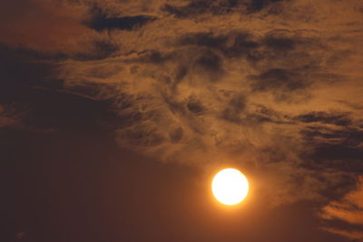 Low angle view of sun shining in sky during sunset