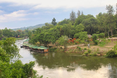 Scenic view of river by trees against sky