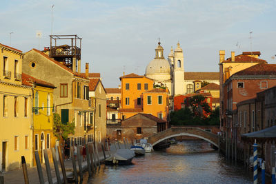 Bridge over canal amidst buildings in city