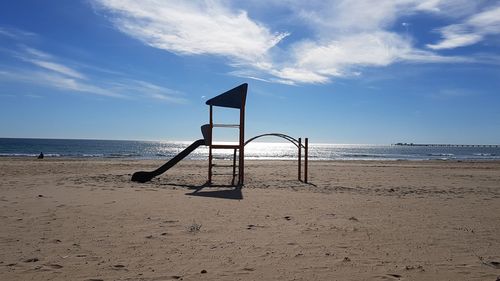 Lifeguard hut on beach against sky