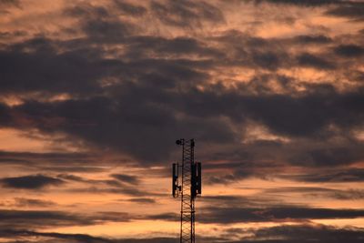 Low angle view of communications tower against sky during sunset