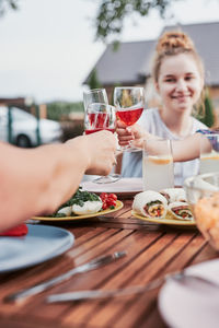 Family making toast during summer outdoor dinner in a home garden