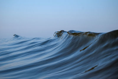 Close-up sea waves against clear blue sky