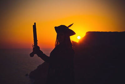 Portrait of a pirate woman at the beach. in anticipation of a pirate ship, sunset