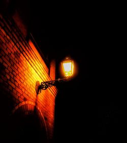 Low angle view of illuminated lamp at night