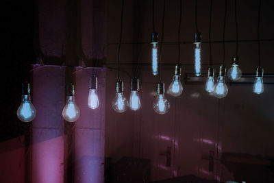 Low angle view of illuminated lights hanging on wall