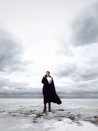 Full length of man standing on beach against sky