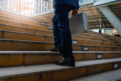 Low section of man standing on staircase