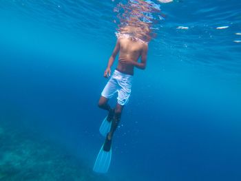 Low section of man swimming in sea