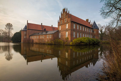 Reflection of building in lake against sky