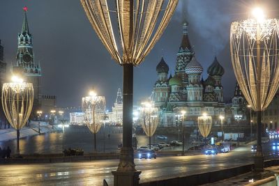 Cars on illuminated street by st basils cathedral at night