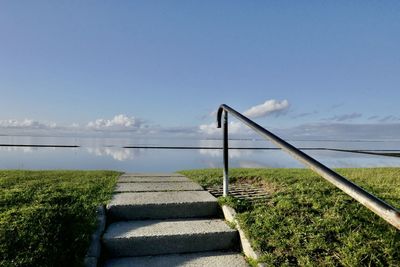 Staircase by sea against sky