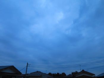 Low angle view of silhouette cables against sky