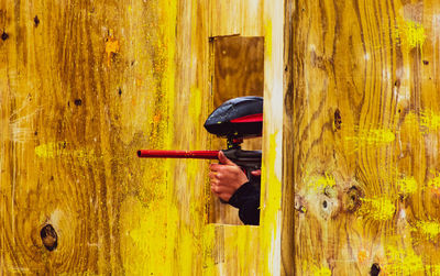 Man holding yellow umbrella on wood