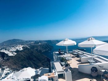 High angle view of sea and mountains against clear blue sky