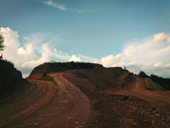 Road by mountain against sky