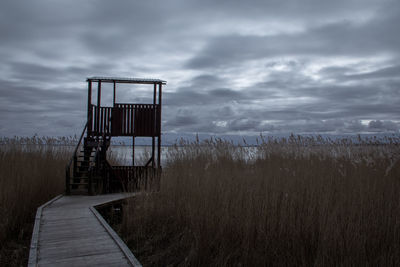 Lifeguard hut on land against sky