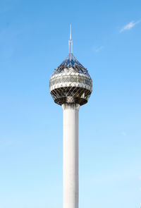 Low angle view of communications tower against blue sky