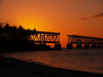 View of bridge over sea at sunset