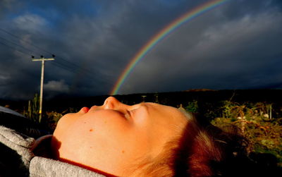 Low angle view of woman lying on rainbow