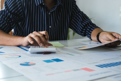 Midsection of business colleagues working on table