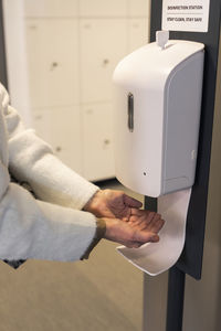 Woman using hand sanitizer dispenser