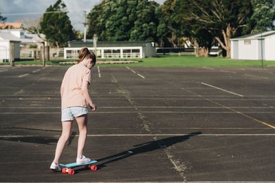 Full length of woman standing on skateboard