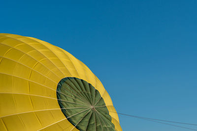 Low angle view of hot air balloon against clear blue sky