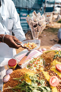 Midsection of man preparing food at market