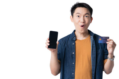 Mid adult man using smart phone against white background