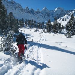 Rear view of man skiing on snow covered mountain against sky