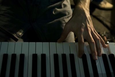 Close-up of hand playing piano