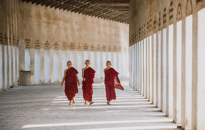 Rear view of people walking in corridor of building