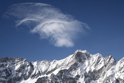 Low angle view of snowcapped mountains against sky