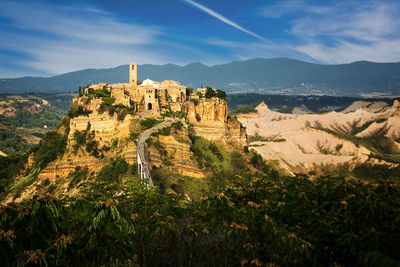 Castle on mountain against cloudy sky