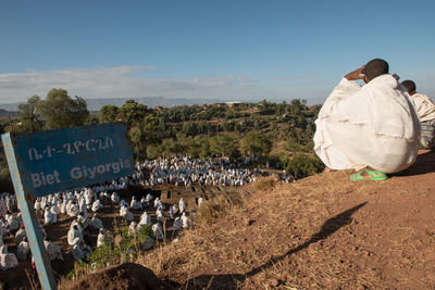Rear view of people on landscape against sky