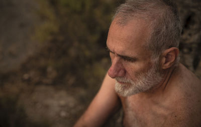 Close-up portrait of shirtless adult man