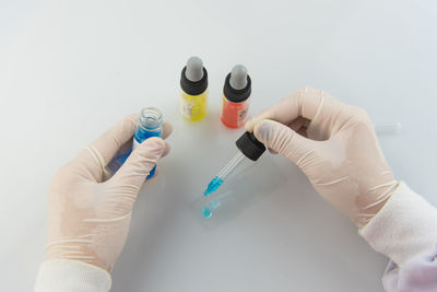 Cropped hands of scientist working with chemicals at table