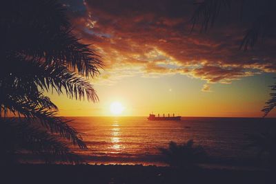 Scenic view of sea against dramatic sky during sunset