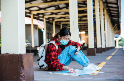 Full length of young woman sitting on paper