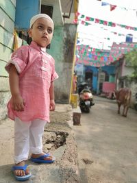 Full length of cute girl standing against pink