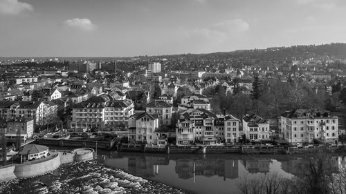 River by cityscape against sky