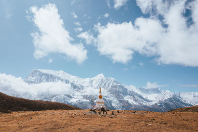 Rear view of woman standing on mountain against sky