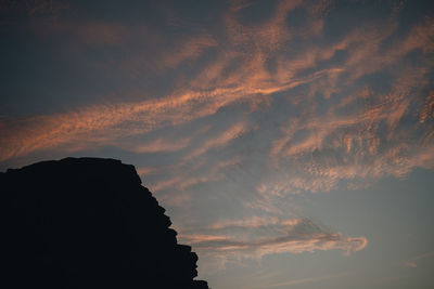 Low angle view of silhouette mountain against sky at sunset