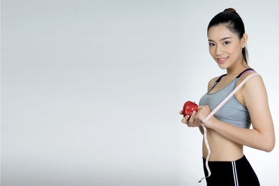 Young woman smiling against white background