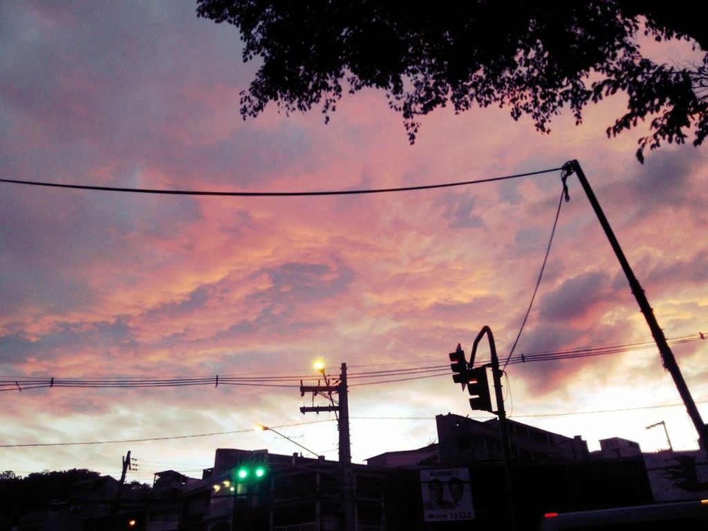 sky, building exterior, architecture, built structure, cloud - sky, sunset, low angle view, power line, silhouette, cloudy, street light, house, cable, electricity pylon, tree, residential structure, residential building, electricity, cloud, dusk