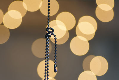 Close-up of necklace against defocused lights at night